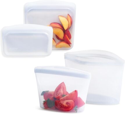 Four clear Stasher reusable silicone bags, including snack, sandwich, 2-cup, and 4-cup sizes, neatly arranged.