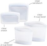 Four clear Stasher reusable silicone bags, including snack, sandwich, 2-cup, and 4-cup sizes, neatly arranged.