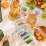 Six transparent SZTCECDM reusable gallon freezer bags with grey zippers, filled with various foods like meat and vegetables.